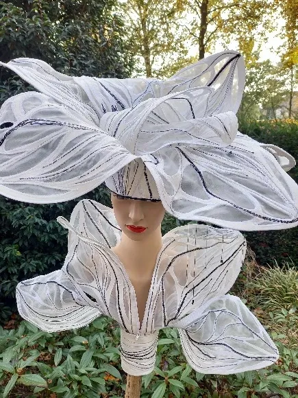 Hoedobject met grote witte bladvormen en zichtbare nerven, op een houten sculptuur